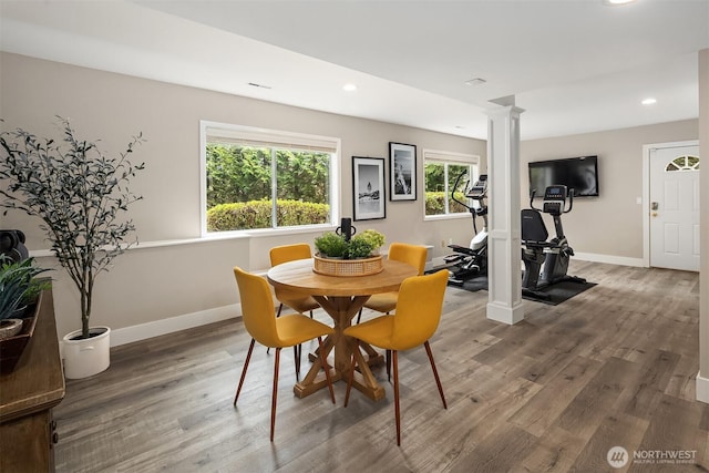 dining space with ornate columns, wood finished floors, and baseboards