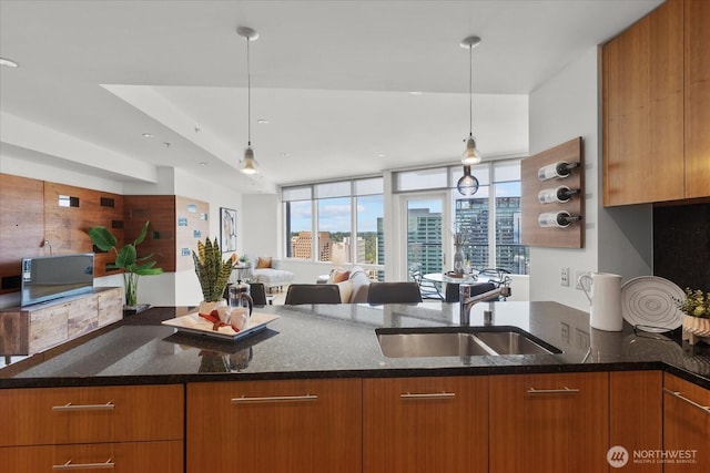 10700 NE 4th St Unit 3108, Bellevue, WA 98004 - kitchen with dark stone counters, open floor plan, brown cabinets, and hanging light fixtures