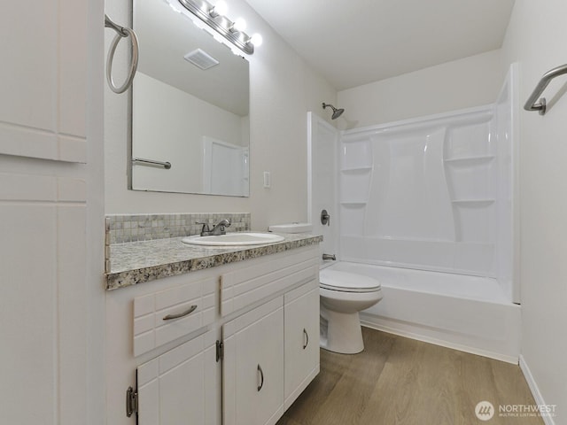 full bath with visible vents, toilet, shower / bathing tub combination, wood finished floors, and vanity