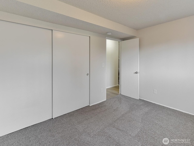 interior space featuring a closet, a textured ceiling, and carpet
