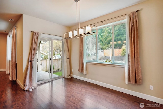 unfurnished dining area with visible vents, baseboards, and dark wood-style flooring