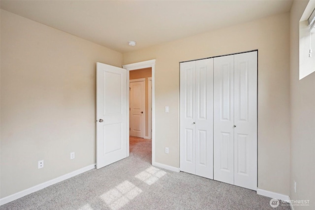 unfurnished bedroom with a closet, baseboards, and carpet