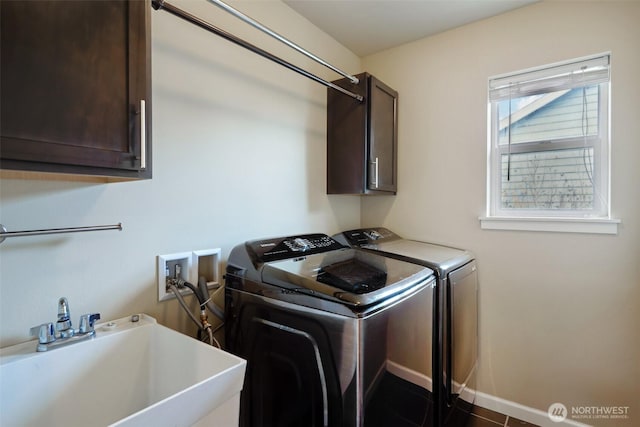 washroom with separate washer and dryer, cabinet space, baseboards, and a sink