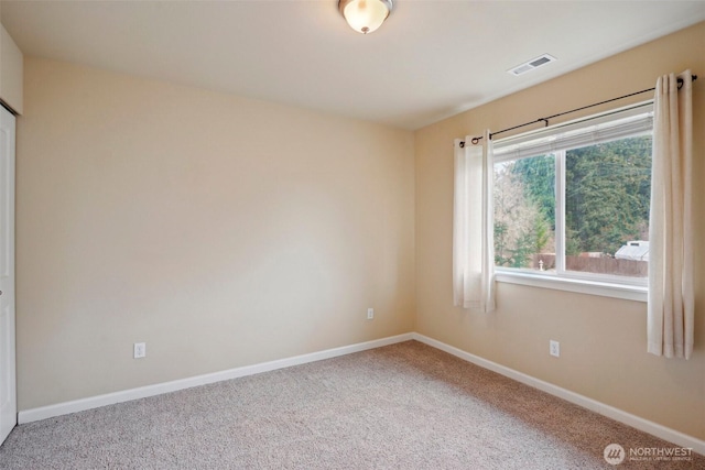 empty room featuring visible vents, baseboards, and carpet