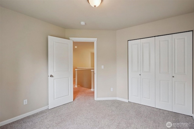 unfurnished bedroom with a closet, baseboards, and carpet
