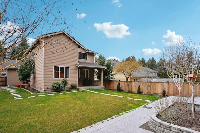 back of property with a yard and fence