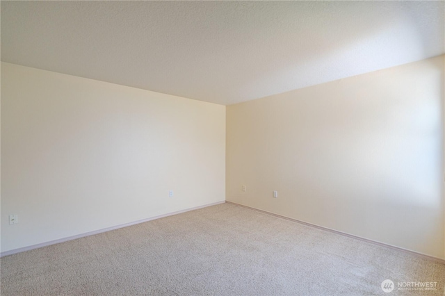 carpeted spare room with baseboards