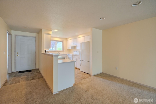 kitchen with white cabinetry, light countertops, light carpet, white appliances, and a peninsula