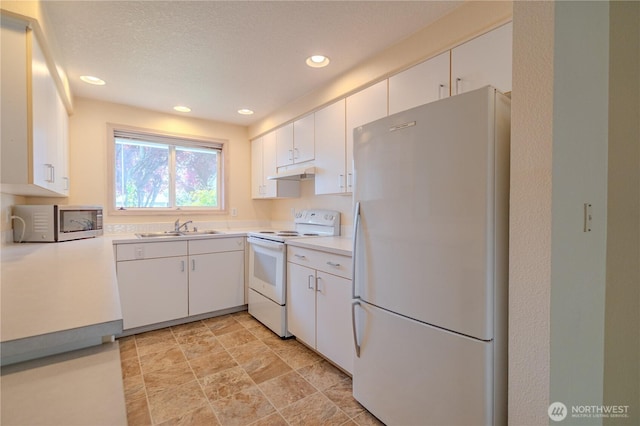kitchen featuring recessed lighting, a sink, under cabinet range hood, white appliances, and light countertops