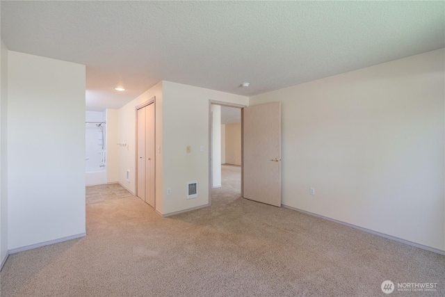 empty room with carpet, visible vents, recessed lighting, and baseboards