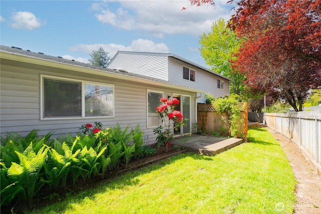 back of house featuring a fenced backyard, a patio area, and a lawn