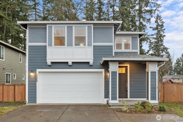 view of front of house featuring fence, an attached garage, and driveway