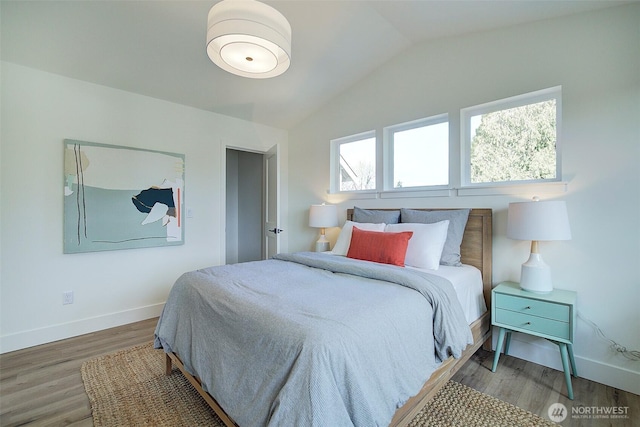 bedroom featuring baseboards, lofted ceiling, and wood finished floors