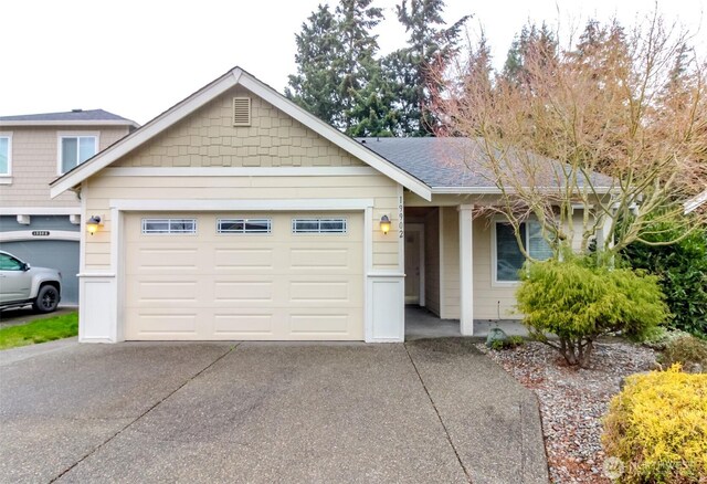 ranch-style house with driveway, a garage, and roof with shingles