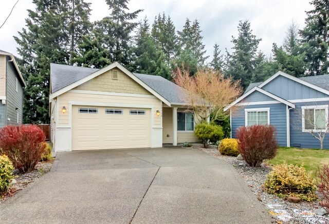 single story home featuring concrete driveway, a shingled roof, and an attached garage