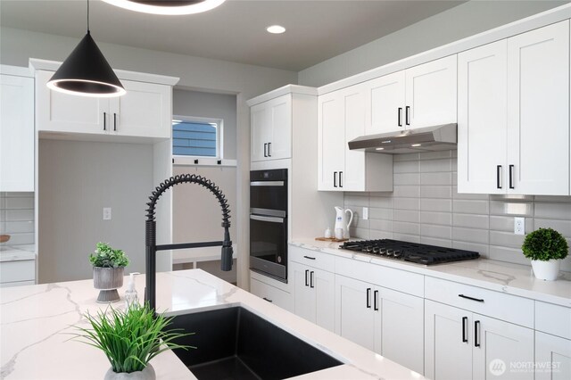 2406 SW Ridgeway Dr, Oak Harbor, WA 98277 - kitchen with stainless steel gas cooktop, under cabinet range hood, tasteful backsplash, white cabinetry, and recessed lighting