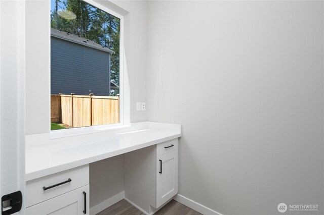 2406 SW Ridgeway Dr, Oak Harbor, WA 98277 - unfurnished office featuring built in desk, wood finished floors, and baseboards