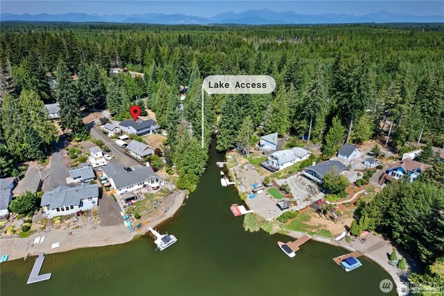 drone / aerial view featuring a forest view, a residential view, and a water and mountain view