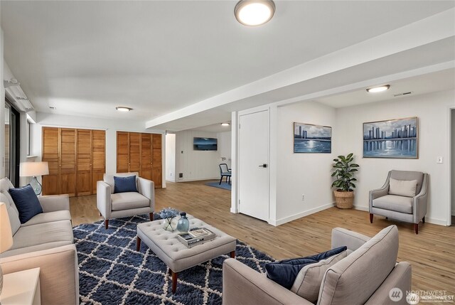 living room with baseboards and light wood finished floors