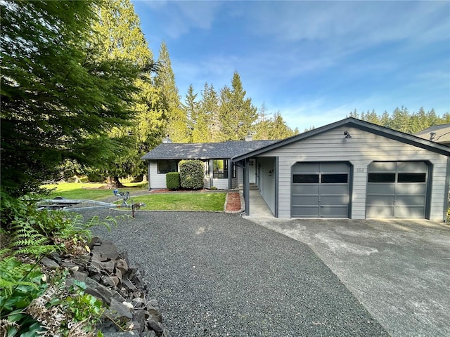 ranch-style house featuring an attached garage, a front yard, and aphalt driveway
