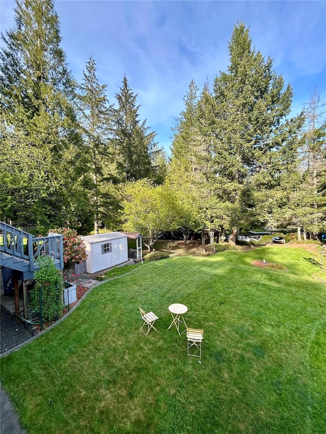 view of yard featuring an outdoor structure and a wooden deck