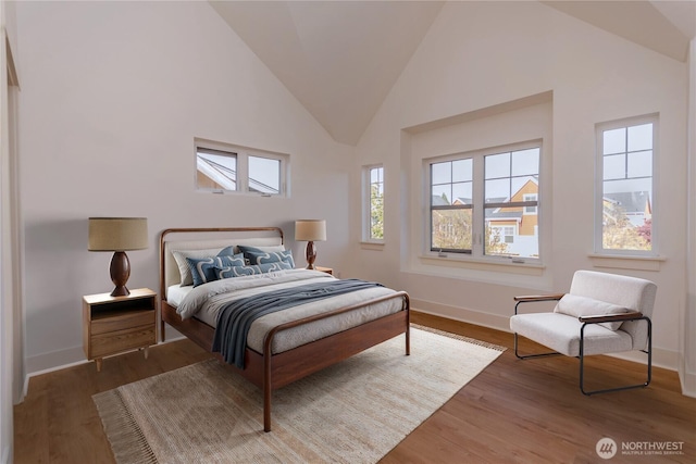 5913 31st Ave SW, Seattle, WA 98126 - bedroom featuring high vaulted ceiling, multiple windows, wood finished floors, and baseboards