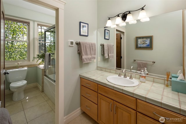 1935 False Bay Dr, Friday Harbor, WA 98250 - bathroom featuring toilet, tile patterned flooring, vanity, enclosed tub / shower combo, and baseboards