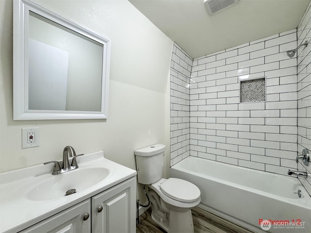 bathroom with wood finished floors, shower / bathing tub combination, vanity, toilet, and visible vents