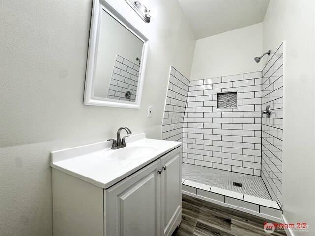bathroom featuring vanity, wood finished floors, and a shower stall