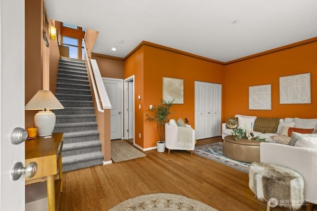 interior space with crown molding, baseboards, stairs, and wood finished floors