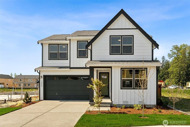 13906 178th Street Ct E Unit 62, Puyallup, WA 98374 - view of front of home with board and batten siding, a shingled roof, driveway, and a garage