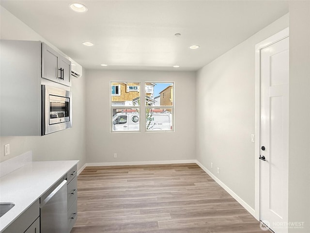 13906 178th Street Ct E Unit 62, Puyallup, WA 98374 - unfurnished dining area with recessed lighting, baseboards, light wood-style floors, and a wall mounted air conditioner