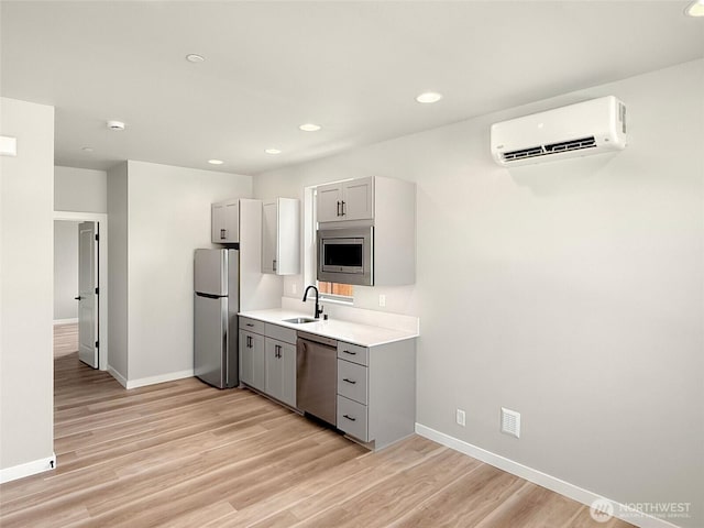 13906 178th Street Ct E Unit 62, Puyallup, WA 98374 - kitchen featuring stainless steel appliances, gray cabinetry, an AC wall unit, a sink, and baseboards