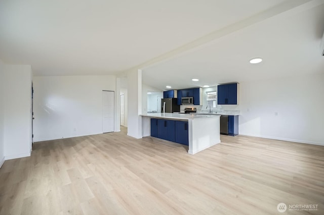 7110 146th St SW Unit 35, Lakewood, WA 98439 - kitchen featuring light countertops, appliances with stainless steel finishes, a peninsula, vaulted ceiling, and blue cabinets