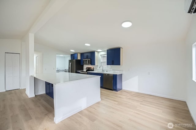 7110 146th St SW Unit 35, Lakewood, WA 98439 - kitchen with blue cabinetry, appliances with stainless steel finishes, light countertops, a sink, and an AC wall unit
