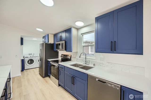 7110 146th St SW Unit 35, Lakewood, WA 98439 - kitchen with separate washer and dryer, light wood-type flooring, blue cabinetry, appliances with stainless steel finishes, and a sink
