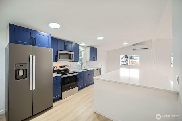 7110 146th St SW Unit 35, Lakewood, WA 98439 - kitchen featuring light wood-style floors, blue cabinetry, a wall mounted AC, appliances with stainless steel finishes, and a sink