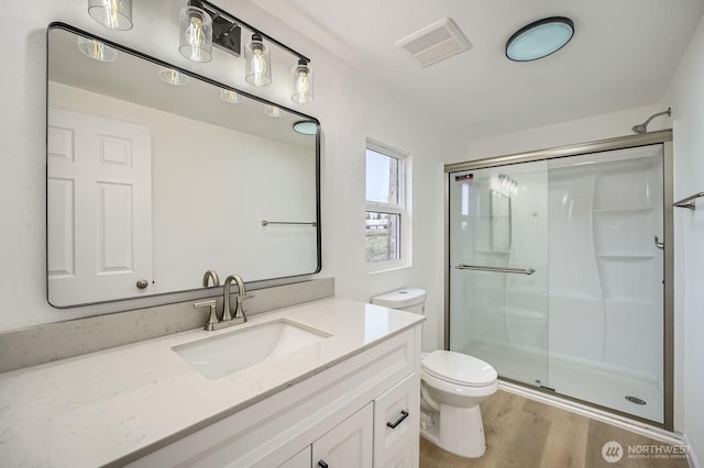7110 146th St SW Unit 35, Lakewood, WA 98439 - bathroom with a shower stall, vanity, visible vents, toilet, and wood finished floors