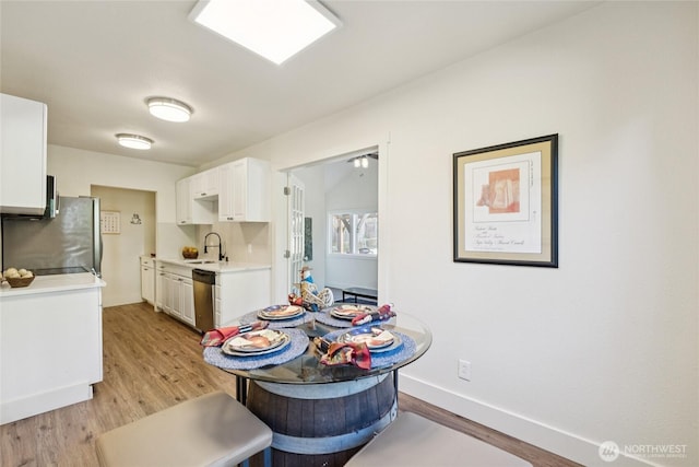 817 SW 158th St, Burien, WA 98166 - kitchen with light countertops, stainless steel appliances, light wood-style flooring, and white cabinetry