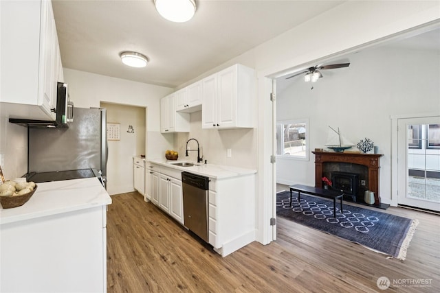 817 SW 158th St, Burien, WA 98166 - kitchen with appliances with stainless steel finishes, wood finished floors, white cabinetry, and plenty of natural light