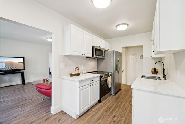 817 SW 158th St, Burien, WA 98166 - kitchen with stainless steel appliances, light wood finished floors, and white cabinets
