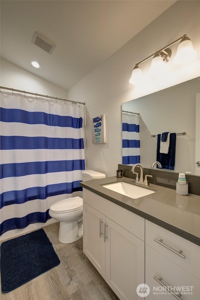 1436 Sand Pebble Ave SW, Ocean Shores, WA 98569 - bathroom featuring visible vents, toilet, a shower with shower curtain, wood finished floors, and vanity