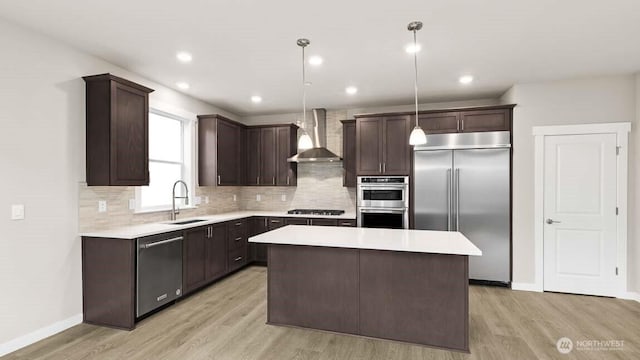 10591 135th Ave NE Unit 24, Kirkland, WA 98033 - kitchen with stainless steel appliances, a sink, wall chimney range hood, dark brown cabinets, and light countertops