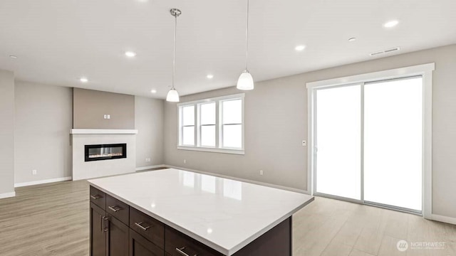 10591 135th Ave NE Unit 24, Kirkland, WA 98033 - kitchen featuring light wood-type flooring, light countertops, a glass covered fireplace, recessed lighting, and baseboards