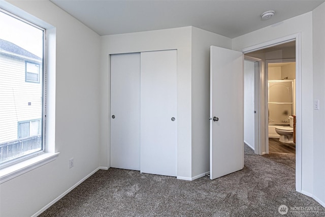 unfurnished bedroom featuring baseboards, carpet, and a closet