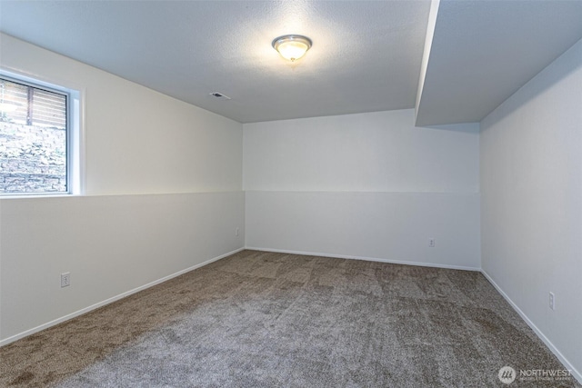 empty room with baseboards, carpet, and visible vents