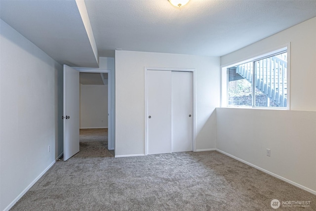 unfurnished bedroom with a closet, carpet flooring, and baseboards