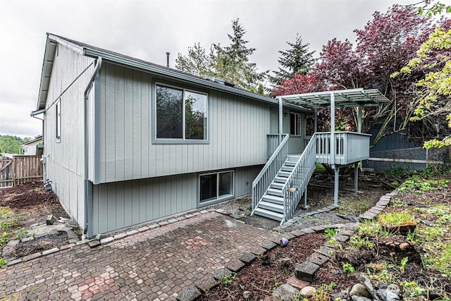rear view of property with fence, a pergola, a deck, a patio area, and stairway