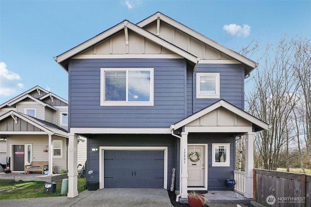 view of front of home featuring board and batten siding, fence, driveway, and a garage