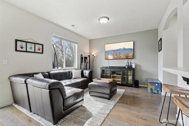 living area with baseboards and wood finished floors